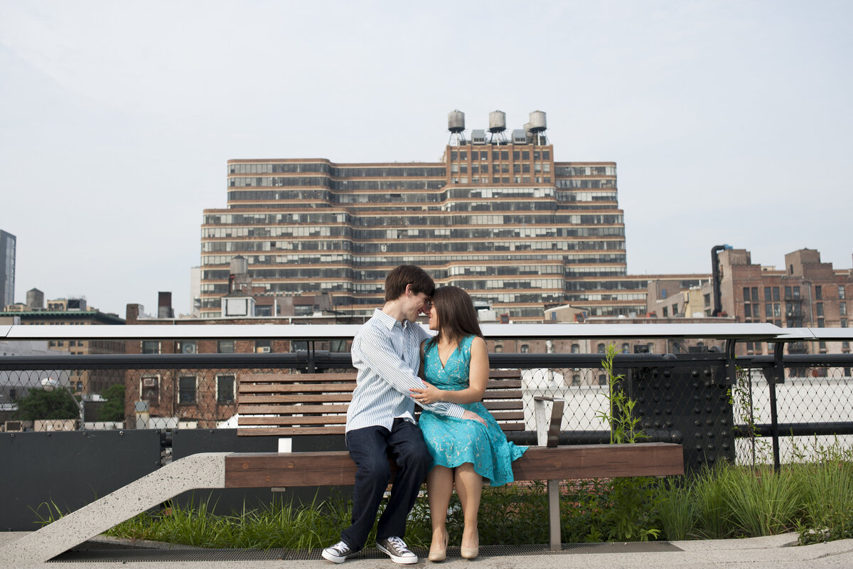 A couple sitting on a bench with their heads together 