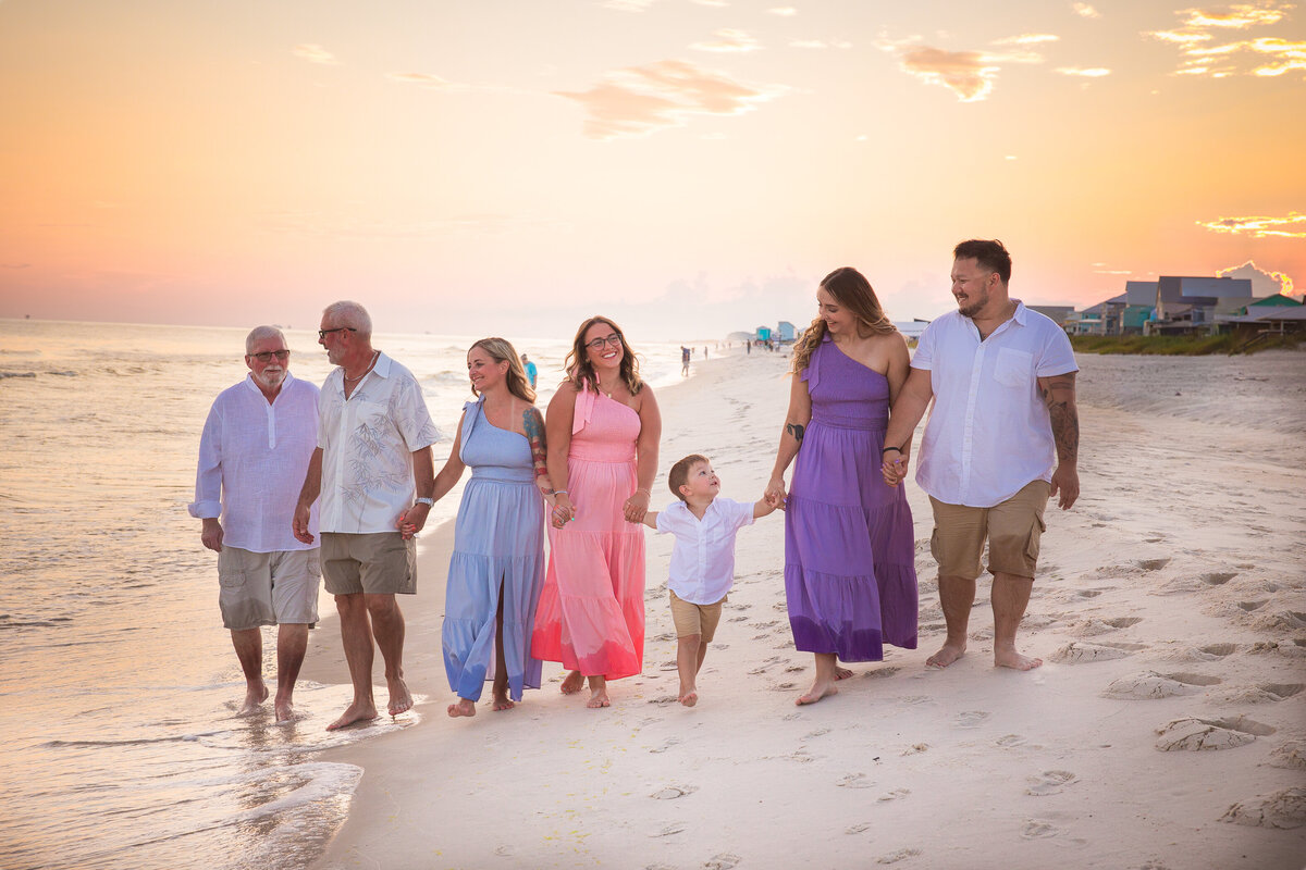 Family enjoying walking along the shoreline with a gorgreous sunset
