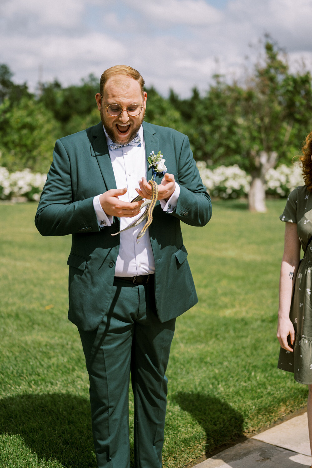 man-in-green-suit-holds-garden-snake