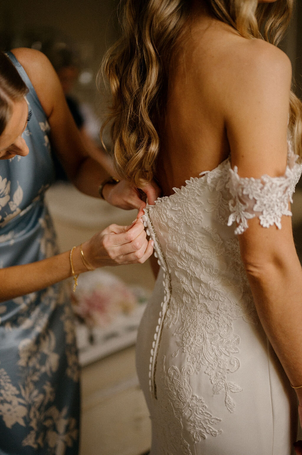 Bridesmaids helping the bride fix her wedding dress