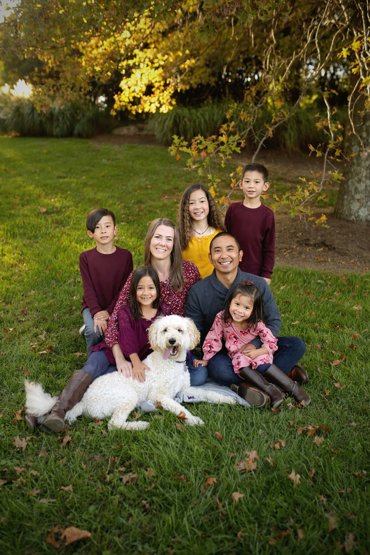 mother and father with five children and large white dog posed on blanket outdoors fall family photoshoot