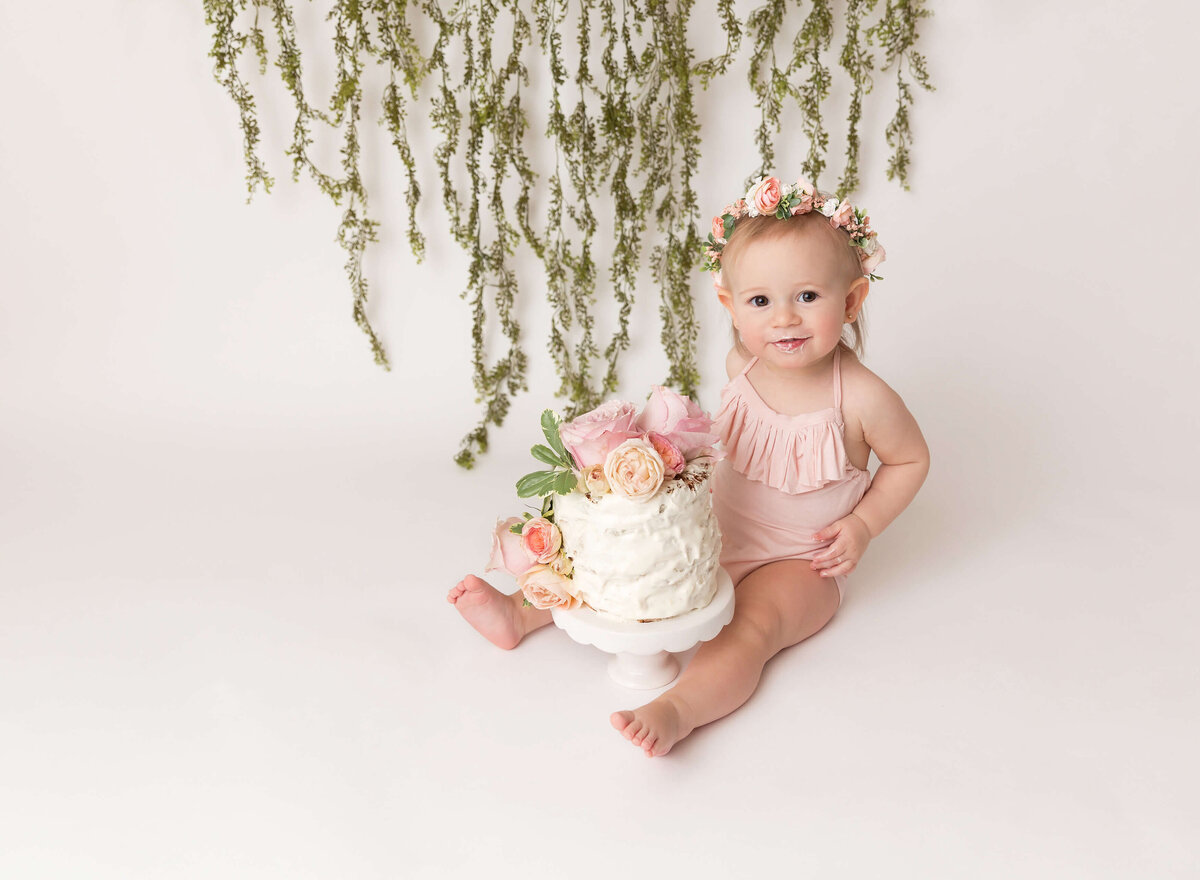 Boho-inspired cake smash photoshoot with a baby girl enjoying their first cake, surrounded by natural elements and fresh flowers. A serene and timeless way to capture milestone moments in NYC