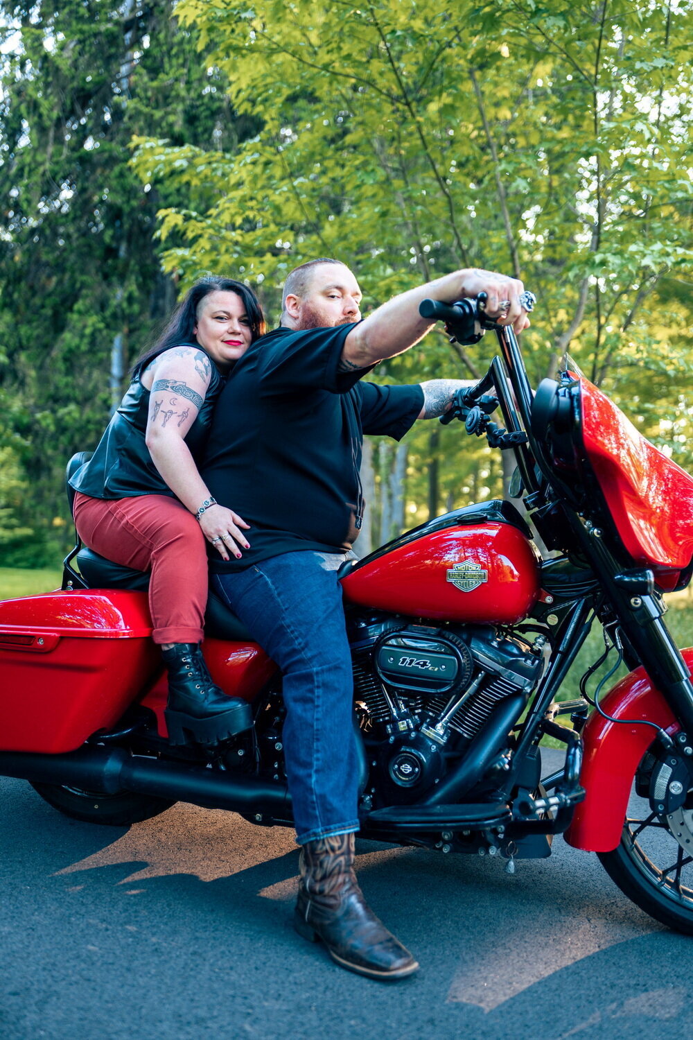 straight White couple posing on a red Harley Davidson motorcycle