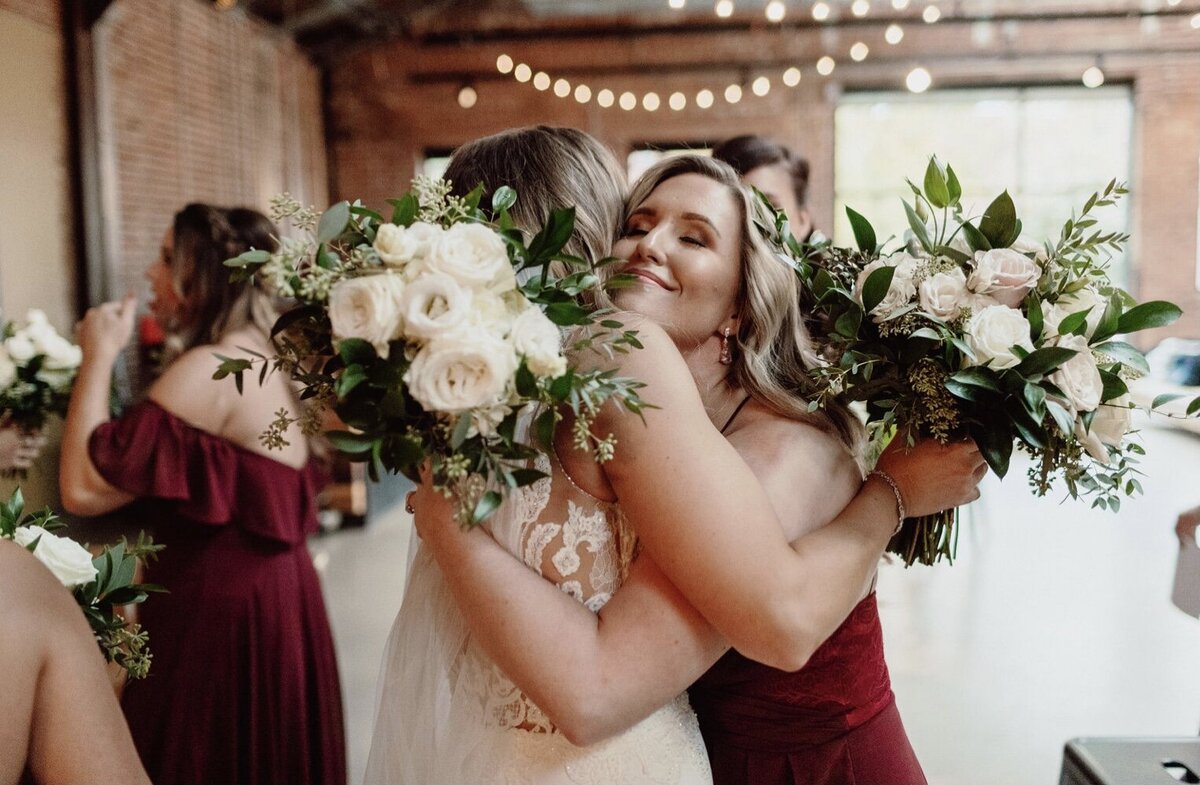 bride-hugging-bridesmaid-flowers