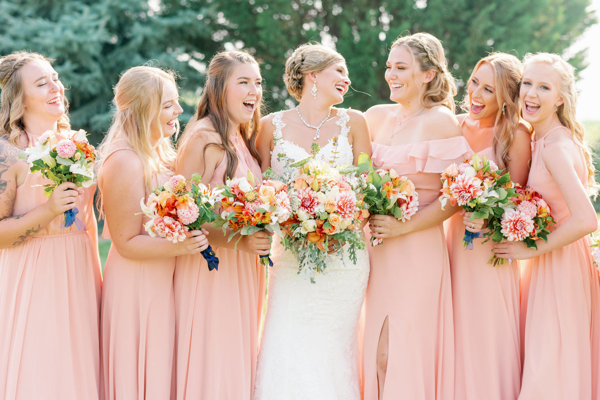 Bride and Bridesmaids laughing in field