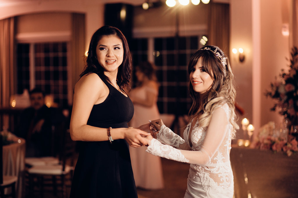 Wedding Photograph Of Bride Dancing With A Woman In Black Jumpsuit Side View Los Angeles