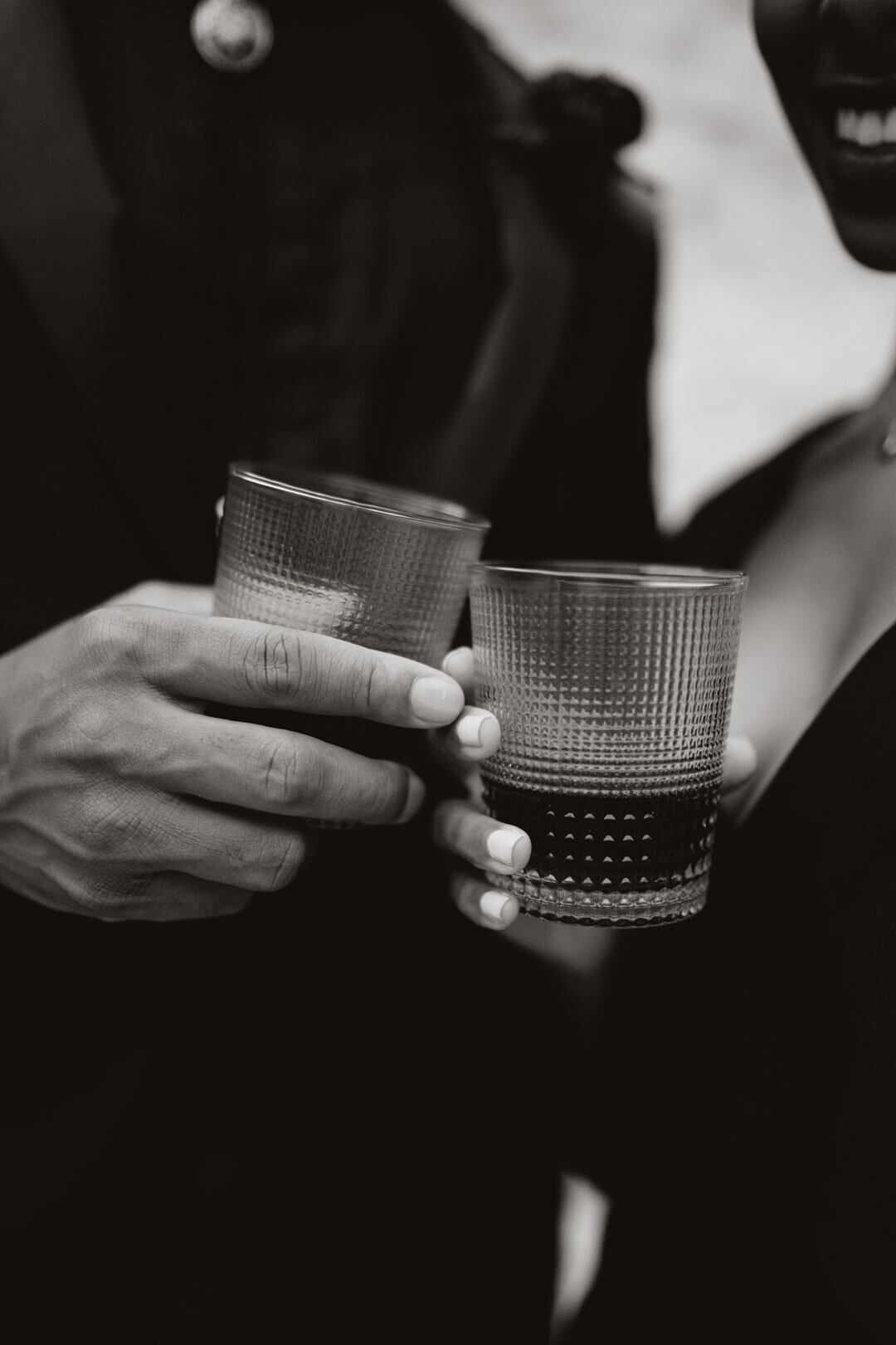 Black and white photo of hands holding glasses
