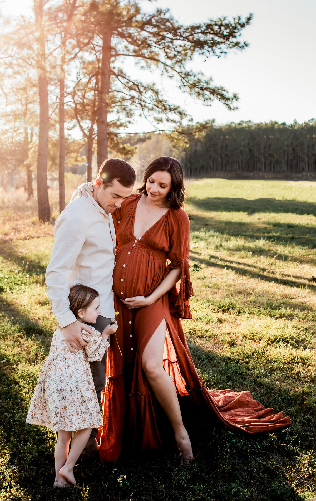 family of 3 is hugging each other  and looking at daughter , field in Perrysburg