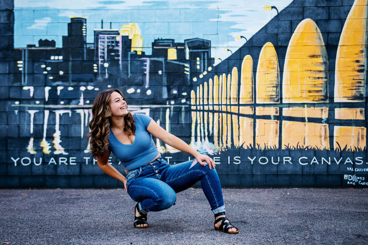outfit idea for high school senior posing in front of city mural