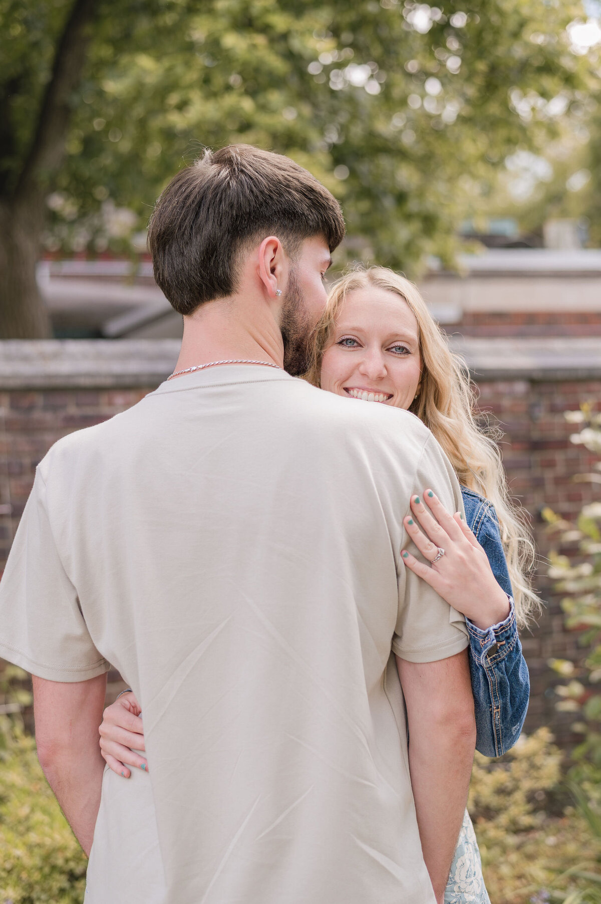 The Workmans during a couples session — she smiles while looking over his shoulder, captured by Bree Stewart of Lens Love Photography.