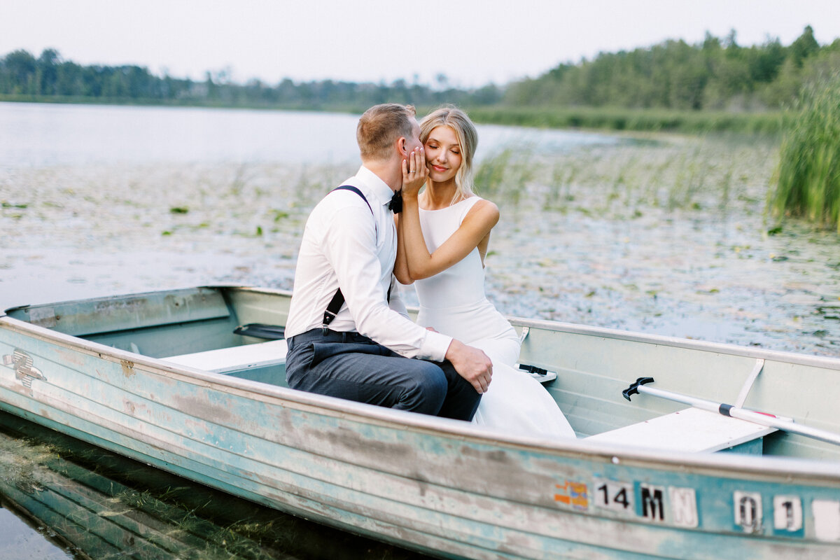 Minneasplis wedding photographer taking a photo of bride and groom kissing in the boat