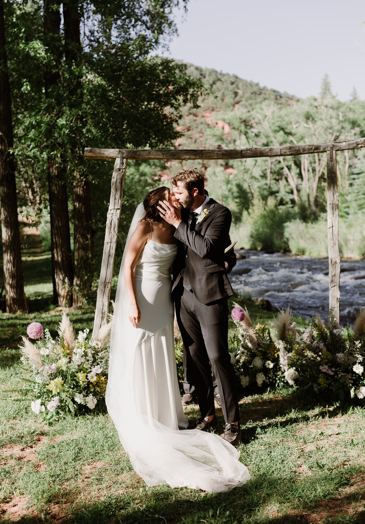 Bride and groom kissing at outdoor wedding ceremony at Dallenbach Ranch Colorado