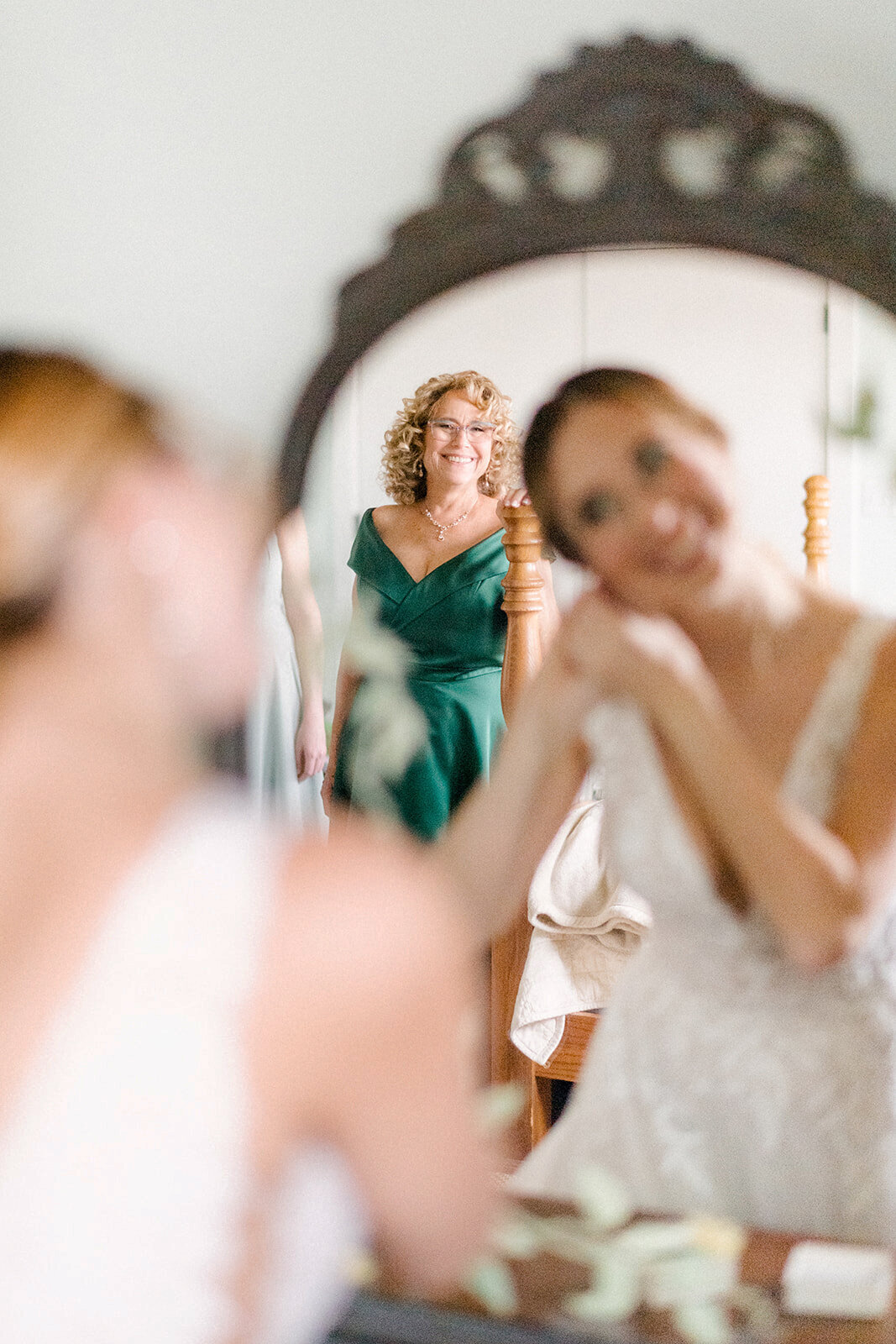 bride getting ready while her mother looks on lovingly