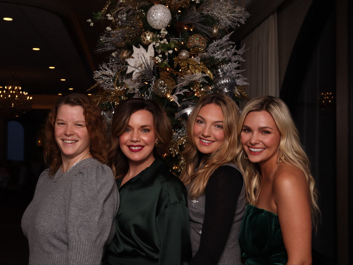 four women smile for the Amarillo Texas glam photo booth at their Christmas party