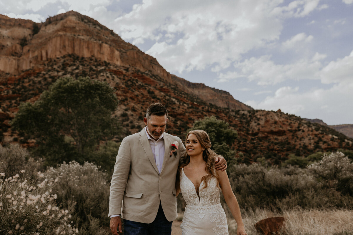 newlyweds walking through the red rocks in the Jemez Mountains in New Mexico