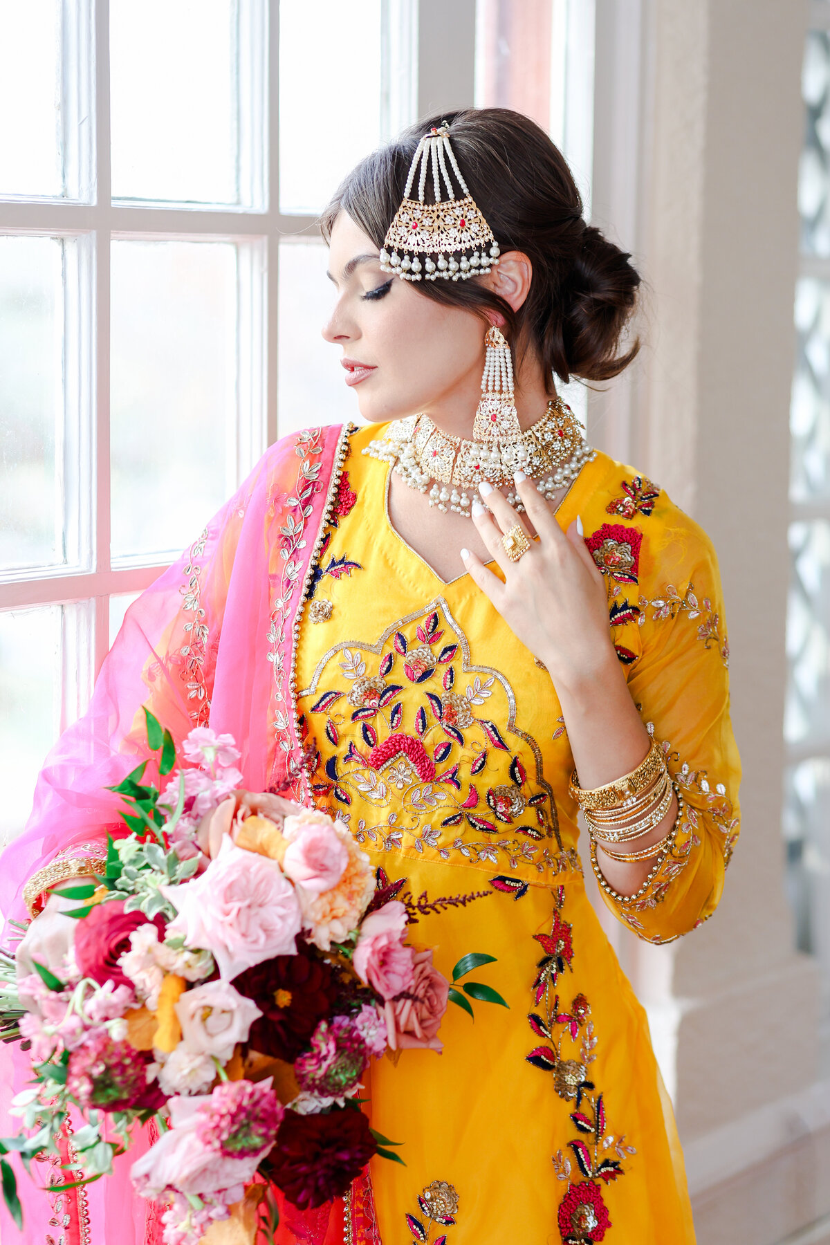 Indian bride wearing red lehenga walking to the mandap