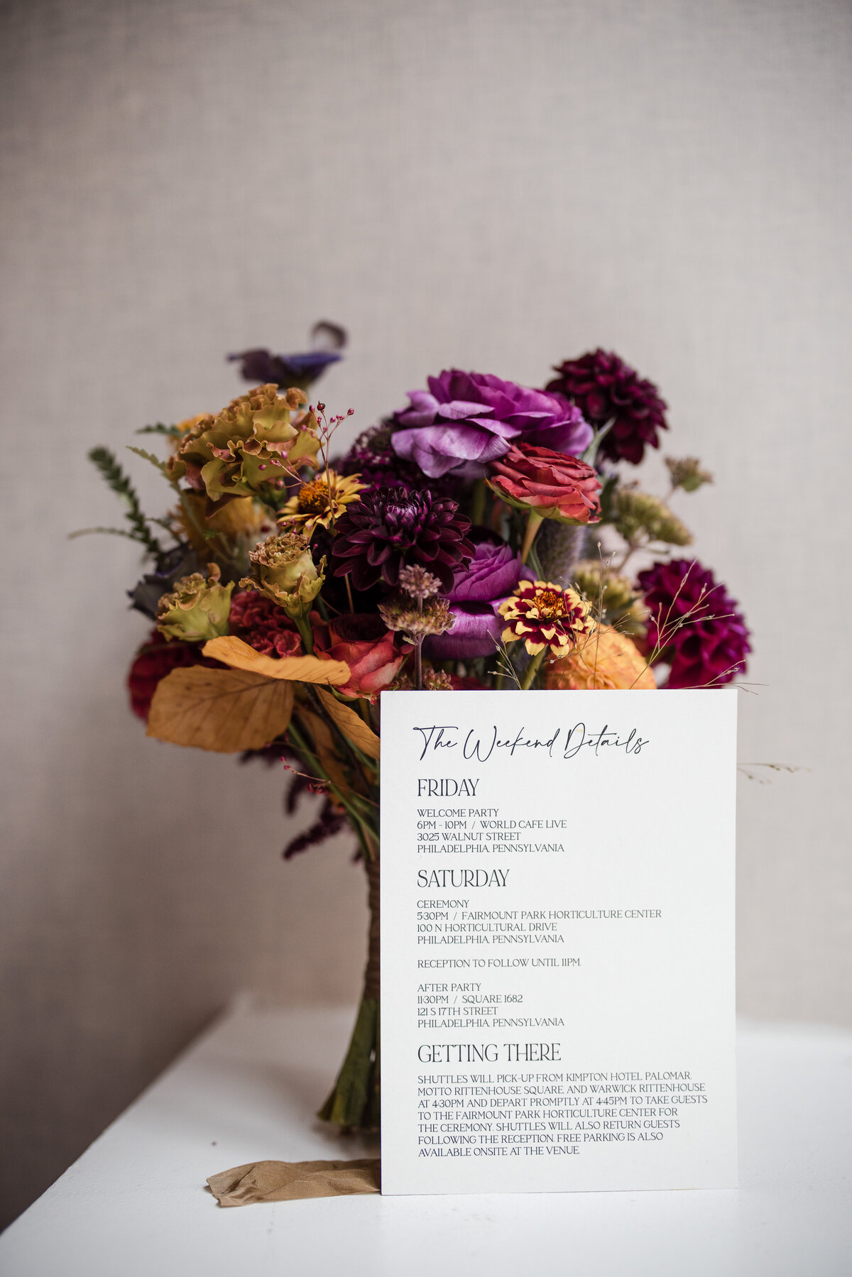 A bouquet and invtation at a  Fairmount Park Horticulture Center wedding