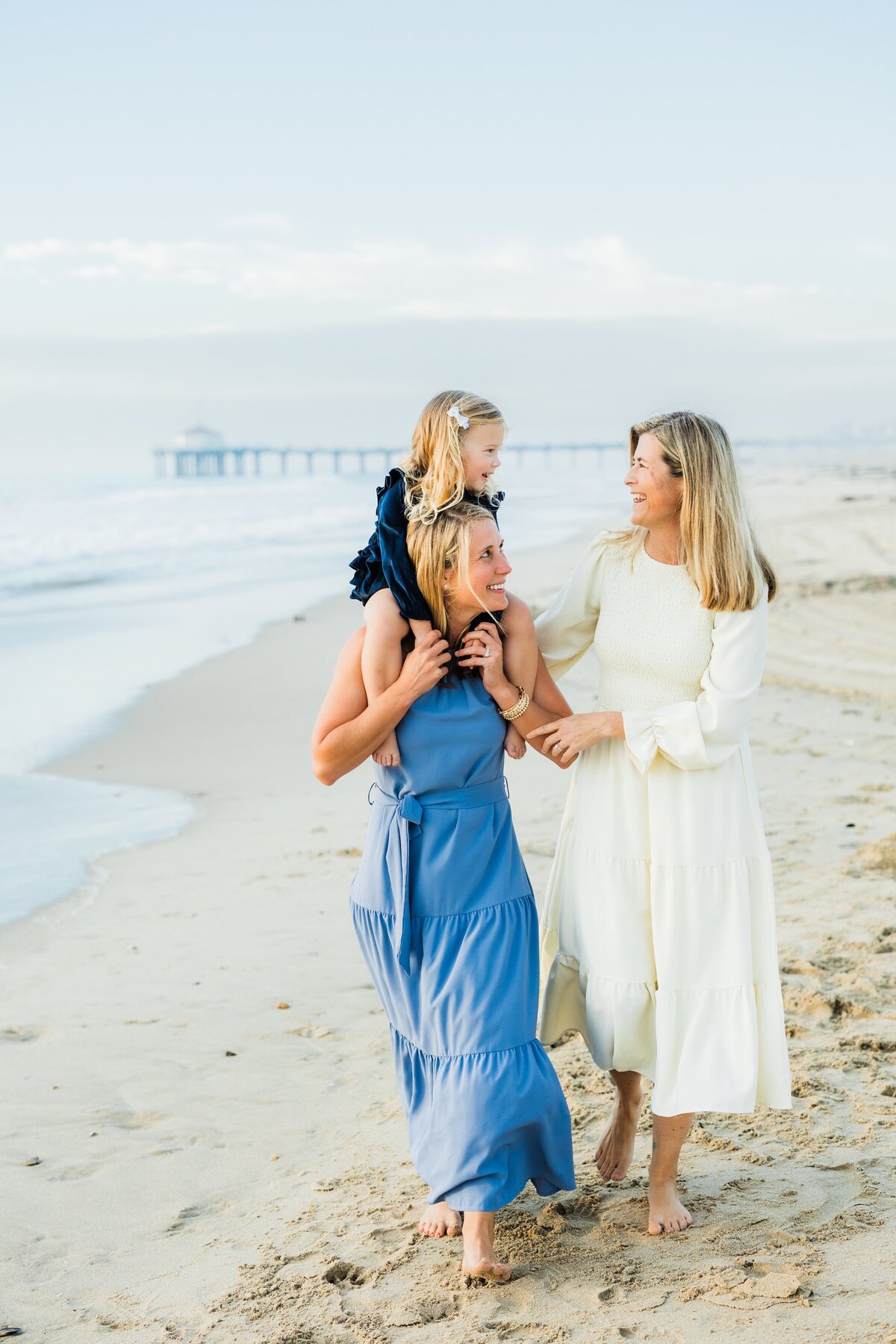 two-moms-walking-on-manhattan-beach-with-daughter