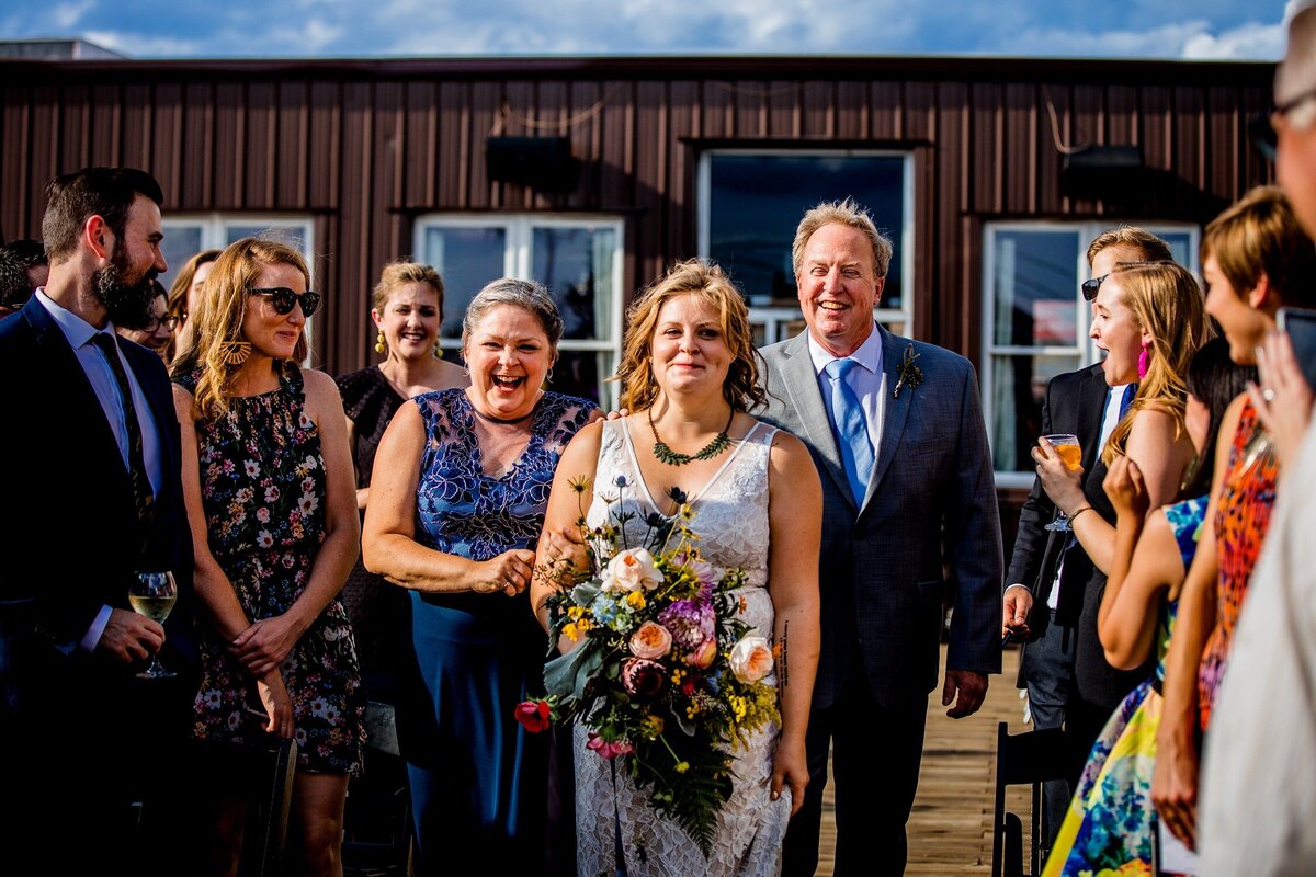 A bride walks down the aisle with her parents at a Bottom Lounge wedding.