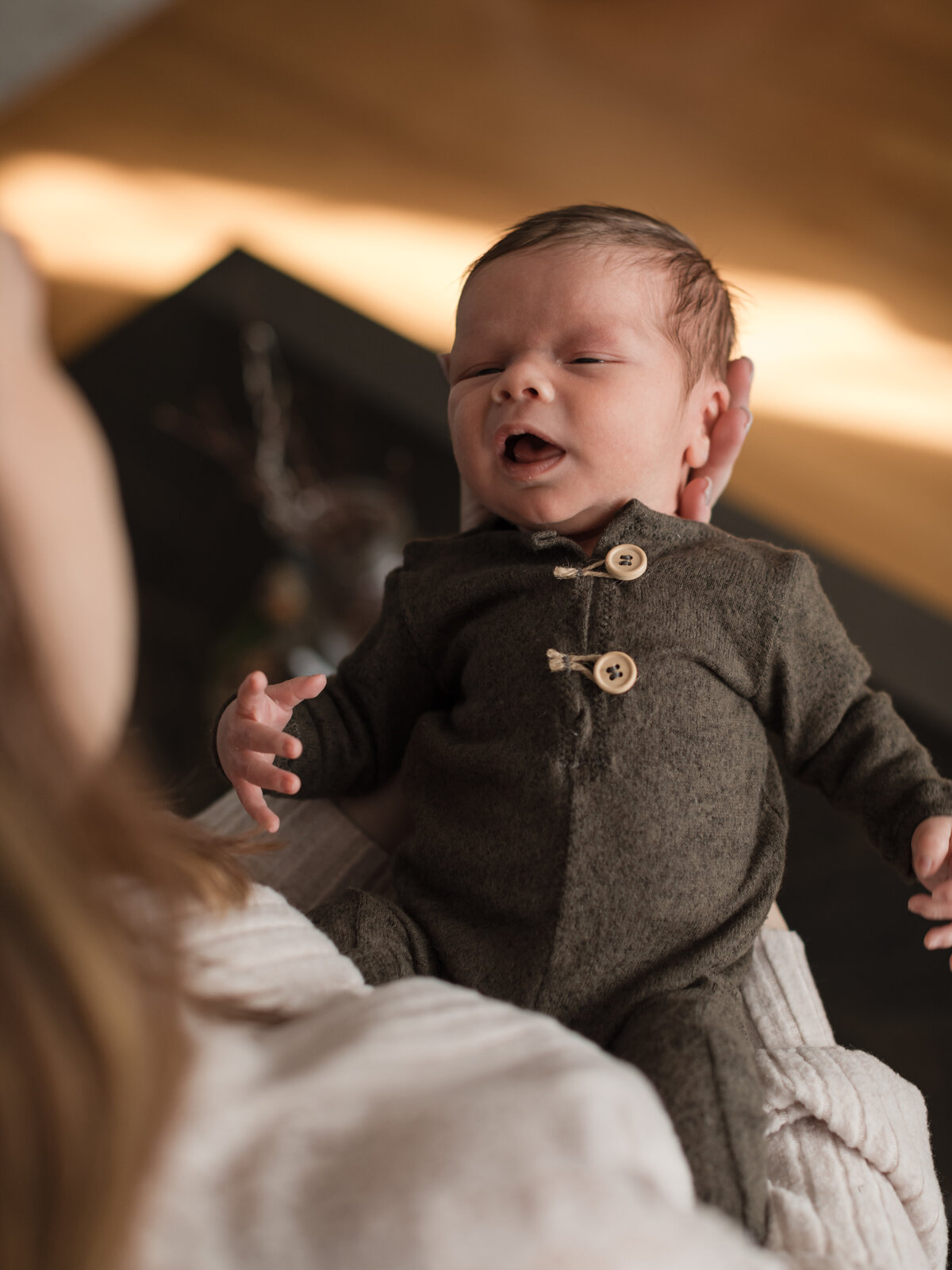 mom holding newborn baby son for in home lifestyle photography session