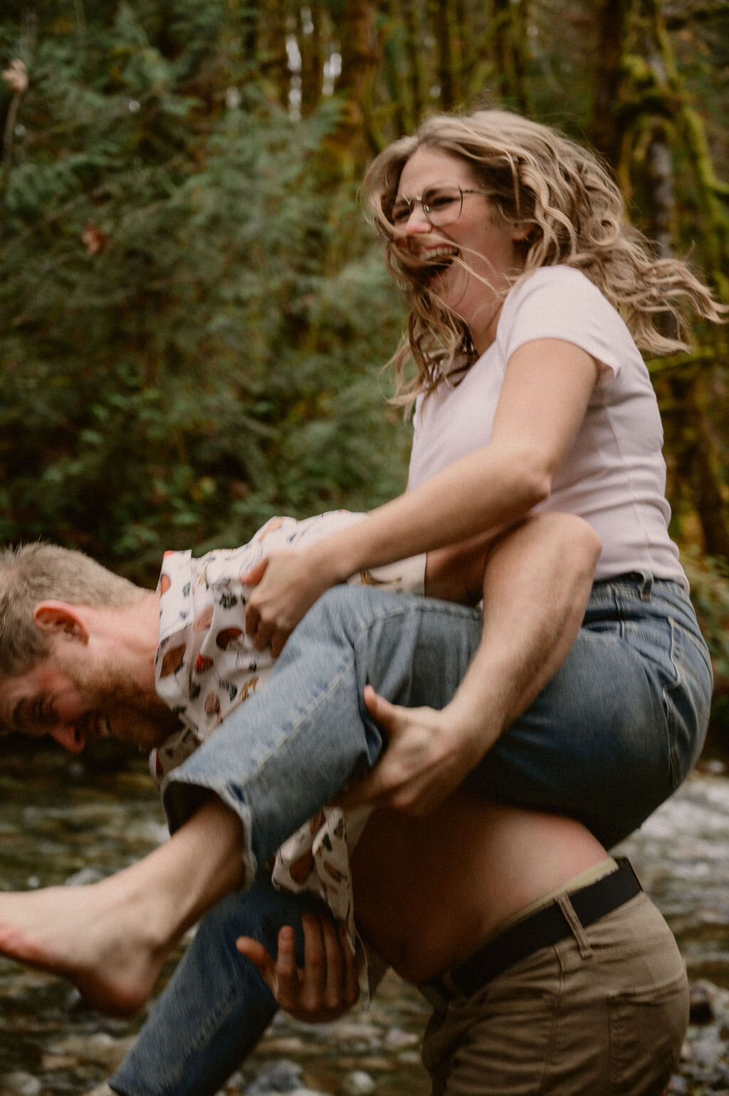 Couple laughing while giving piggyback ride at the river