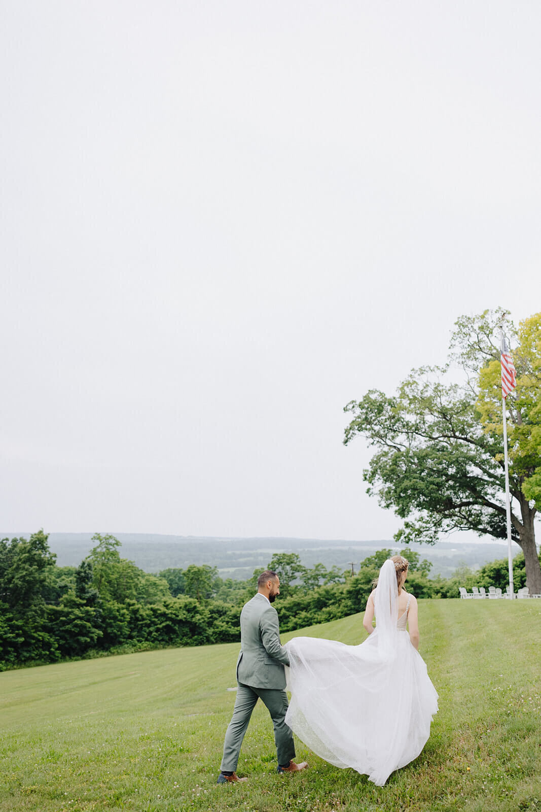 Groom holding brides dress at Mansion at Keuka Lake, NY