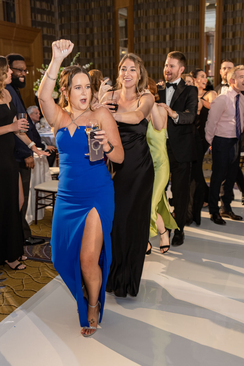 A woman in a blue dress is dancing with a group of people
