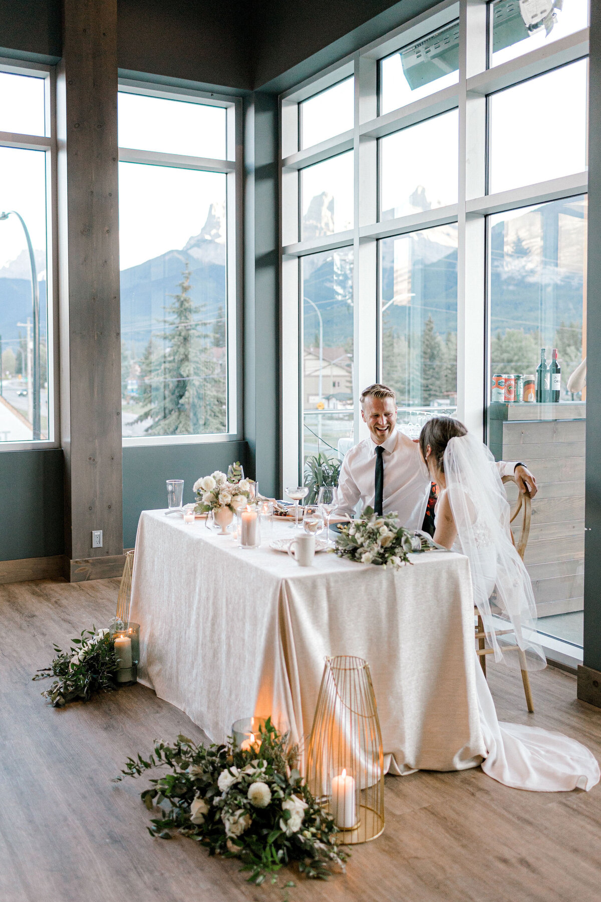 Bride and groom at sweetheart table at The Sensory, a romantic wedding venue in Canmore, Alberta featured on the Brontë Bride Vendor Guide.