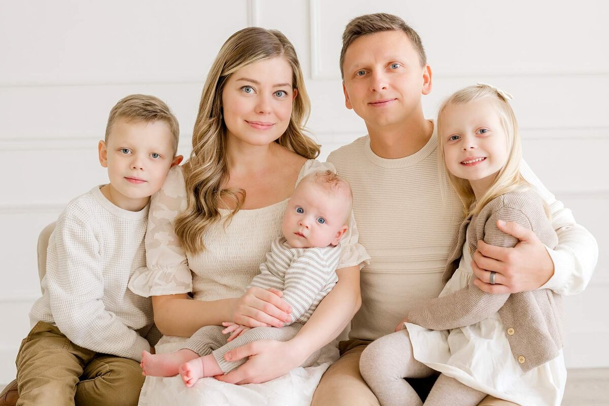A family of five's laughter and love shine through during a playful, minimalist studio session at Alexandra Robyn Photo + Design
