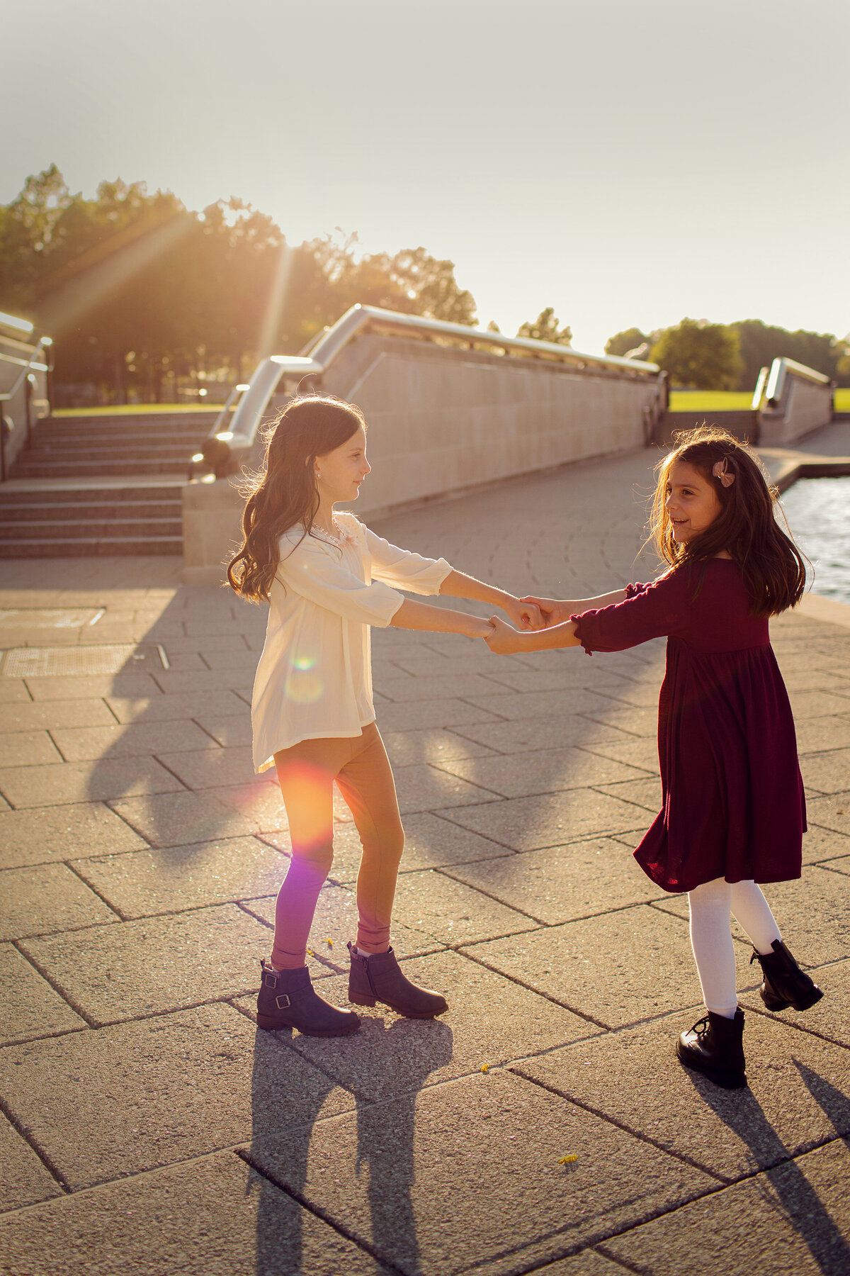 Downtown Indianapolis for this session of sibling girls, the sun coming in behind them.
