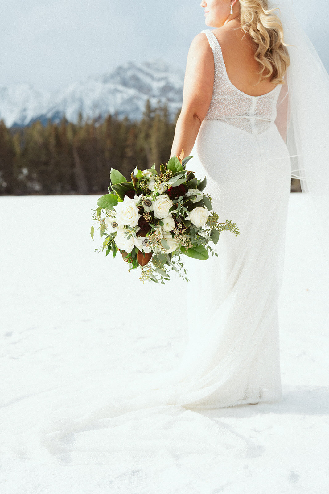 Bride with her bouquet  with mountains in the background.