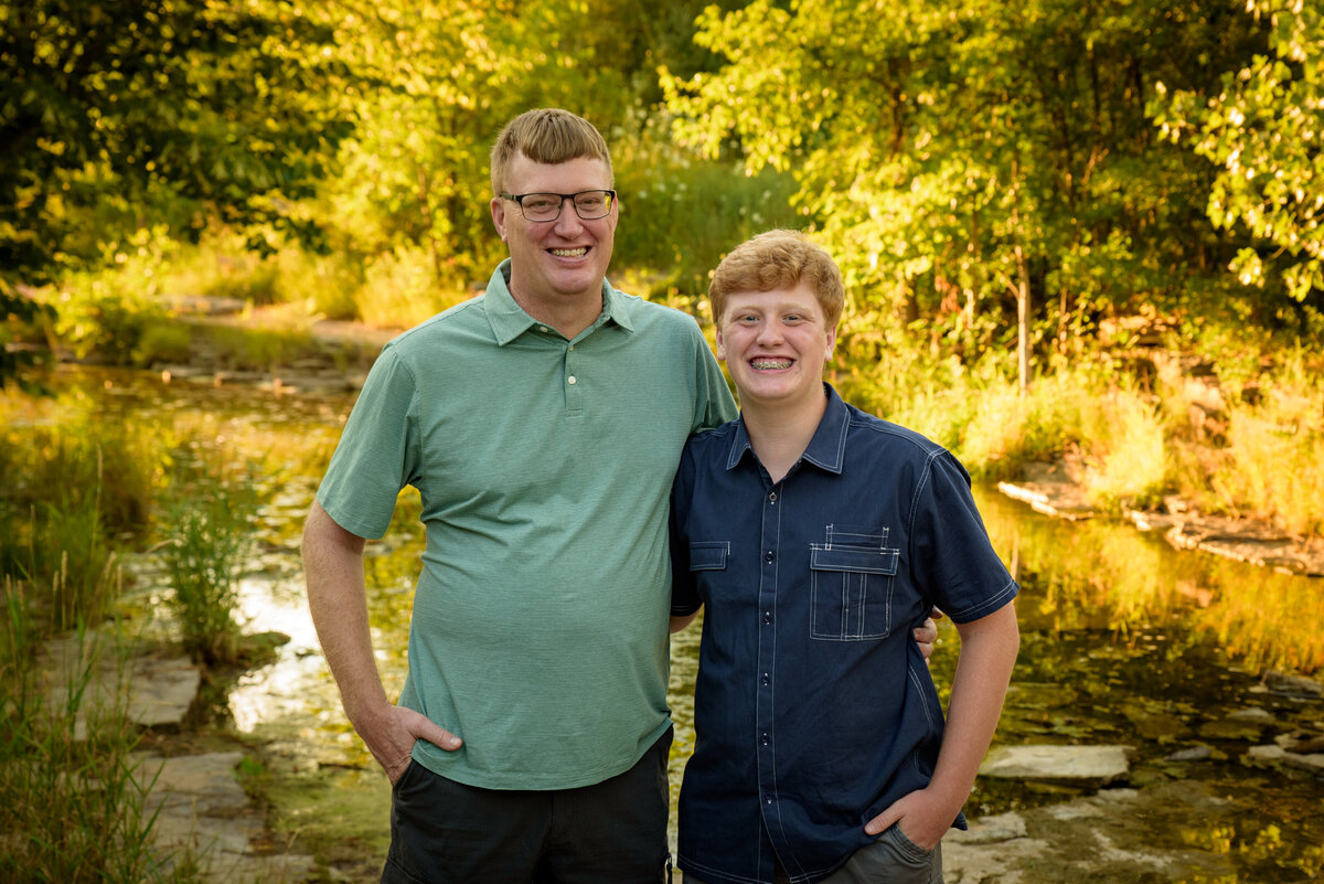 Father and son portrait standing with arms around each other near the creek at Fonferek Glen County Park near Green Bay, Wisconsin