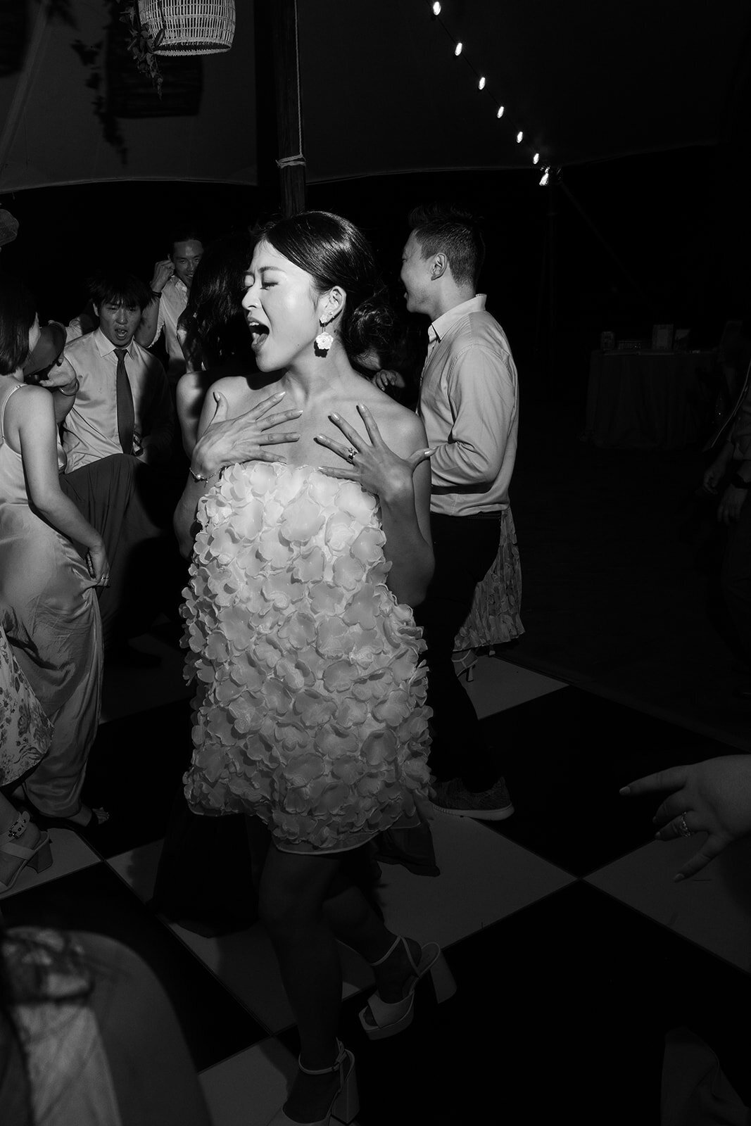 Bride in a dress dancing with other people around