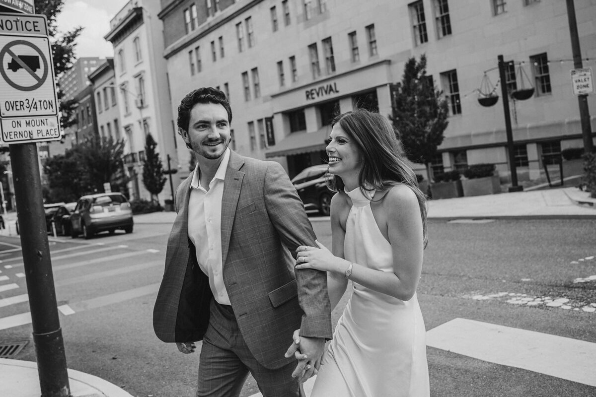 Two people holding hands and walking across a crosswalk 