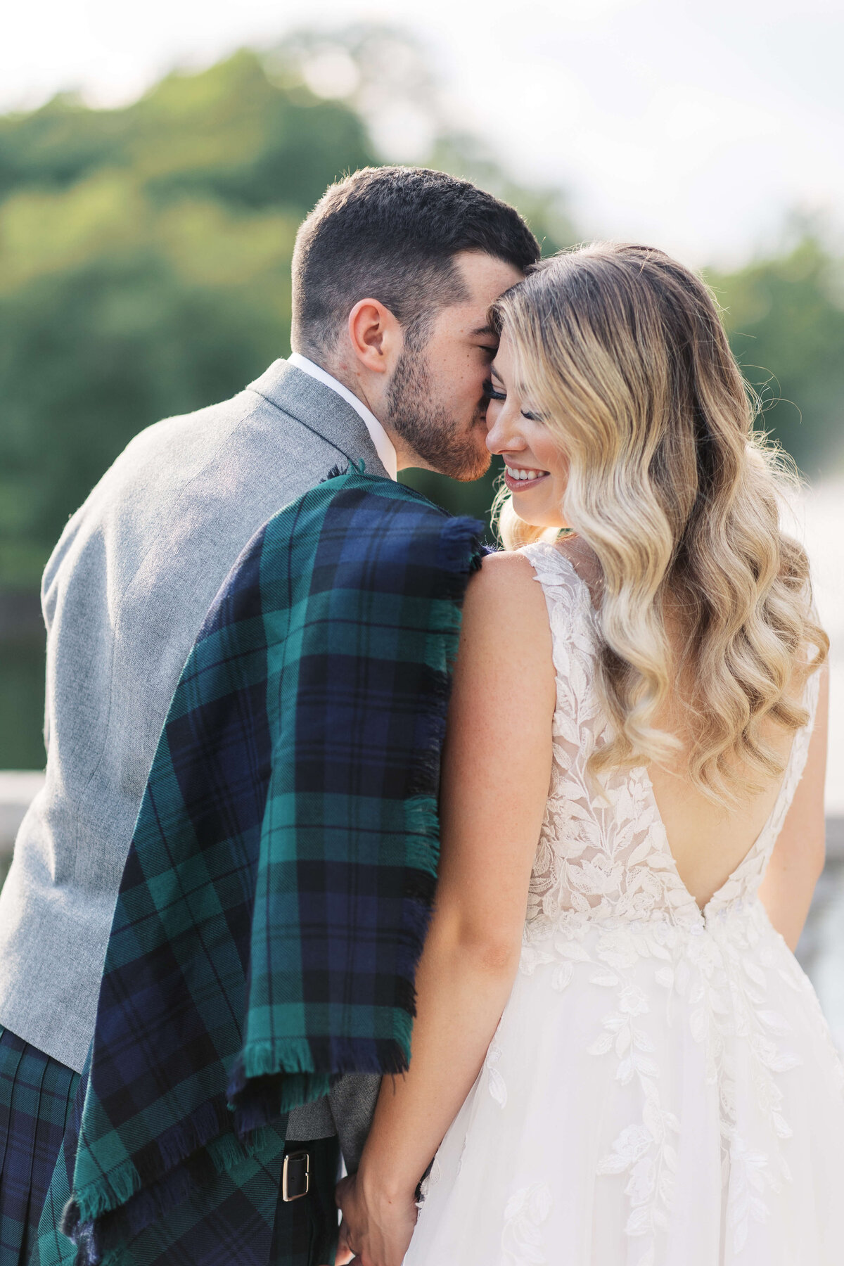 Bride in wedding gown with her groom who is wearing traditional Scottish wedding attire.
