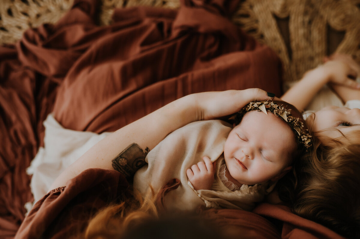 A mom holding her newborn daughter in her arms in a photography studio in fort worth, texas