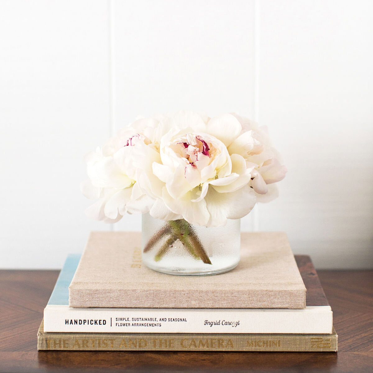 Stack of books with a vase of flowers