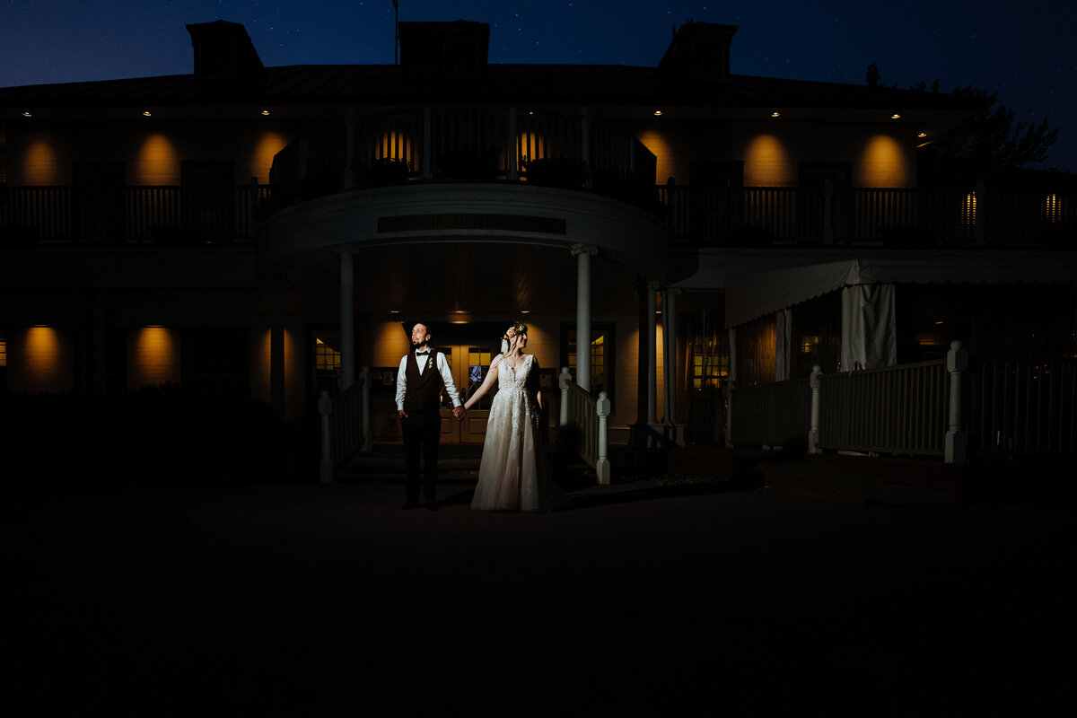 newlyweds-standing-side-by-side-at-dusk-in-front-of-the-manoir-montmorency-1