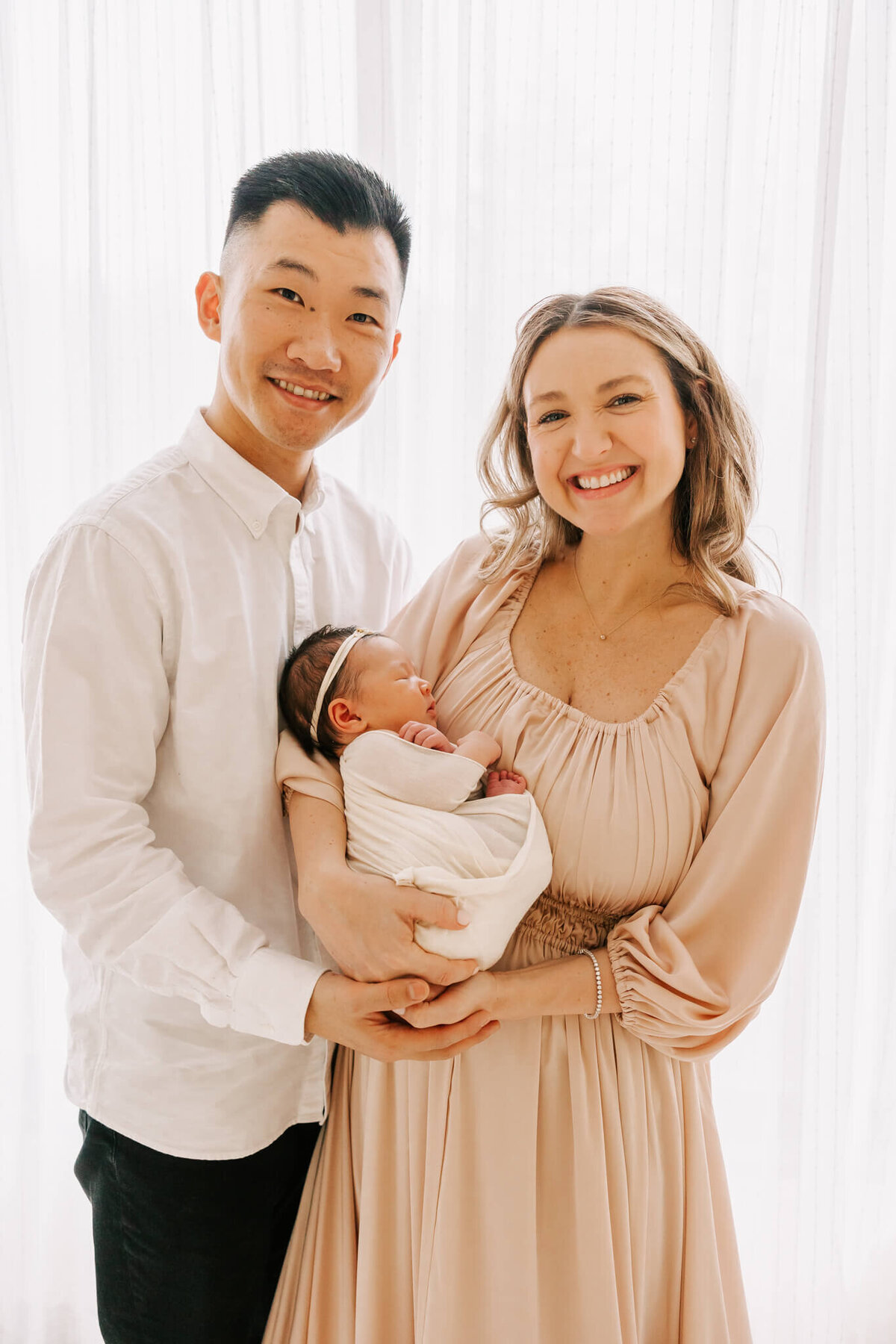 smiling family portrait with newborn girl.