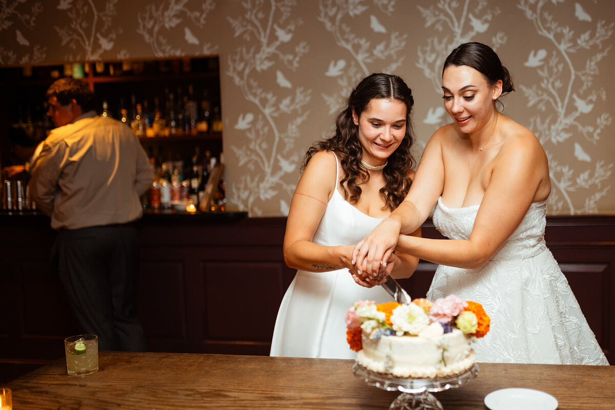 Brides cutting into their wedding cake