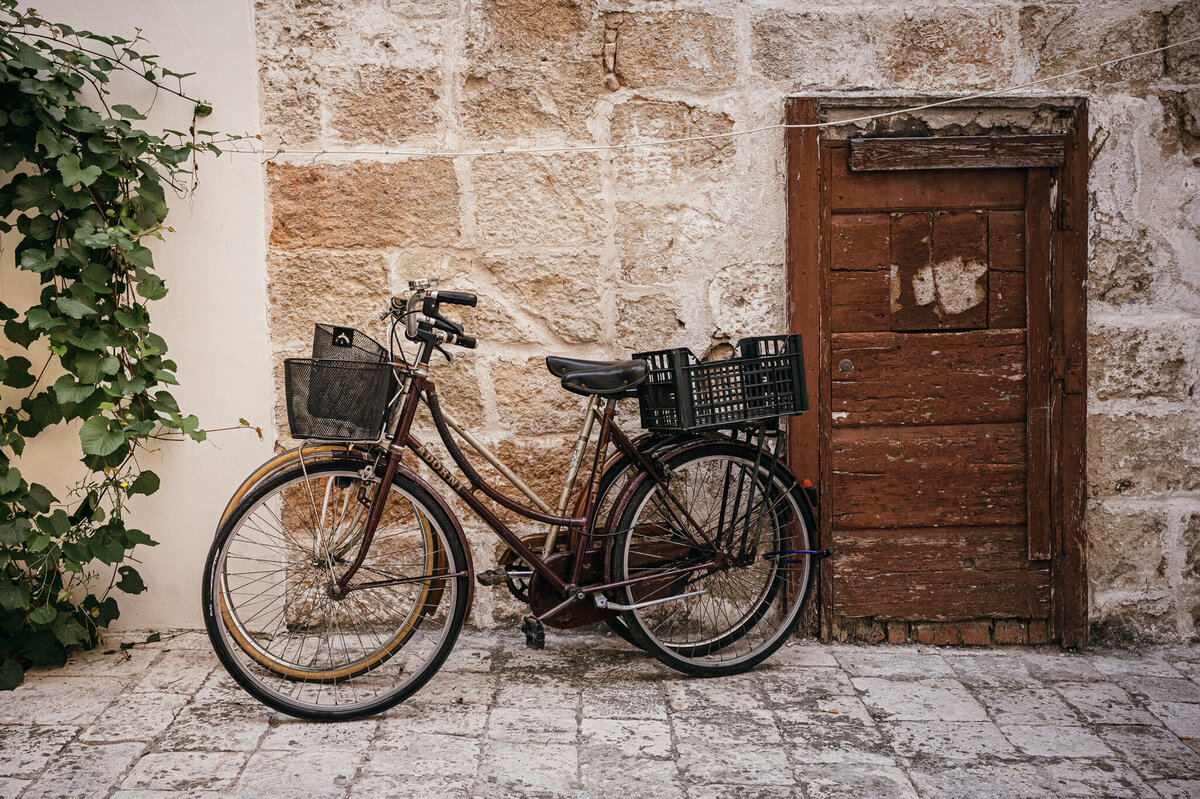 A pair of bikes leaning up agains the walled city of Matera