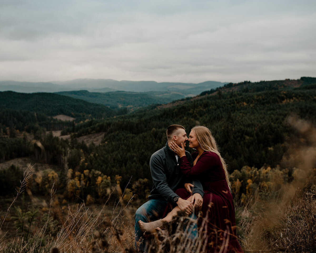 Couple sits together overlooking a clear cut of trees in Monmouth Oregon