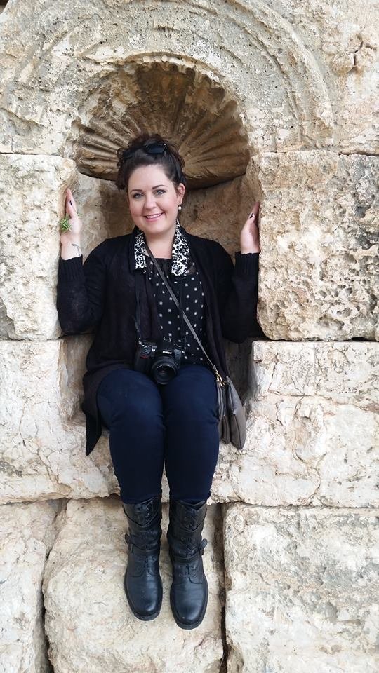 Jill Blue Photography sits in an arch in the Roman ruins of Jaresh, Jordan