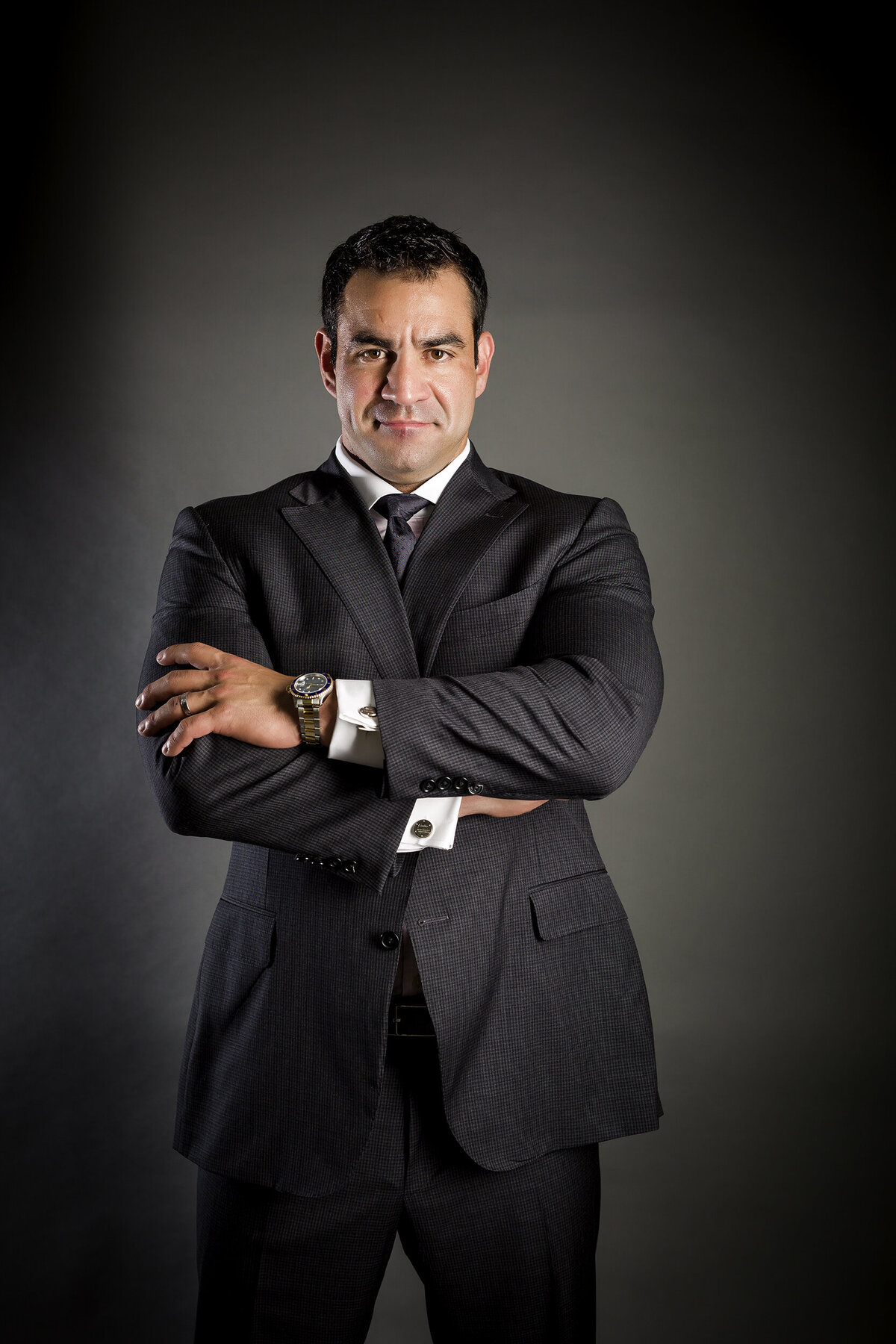 Headshot image of a man in a suit posed in a power stance