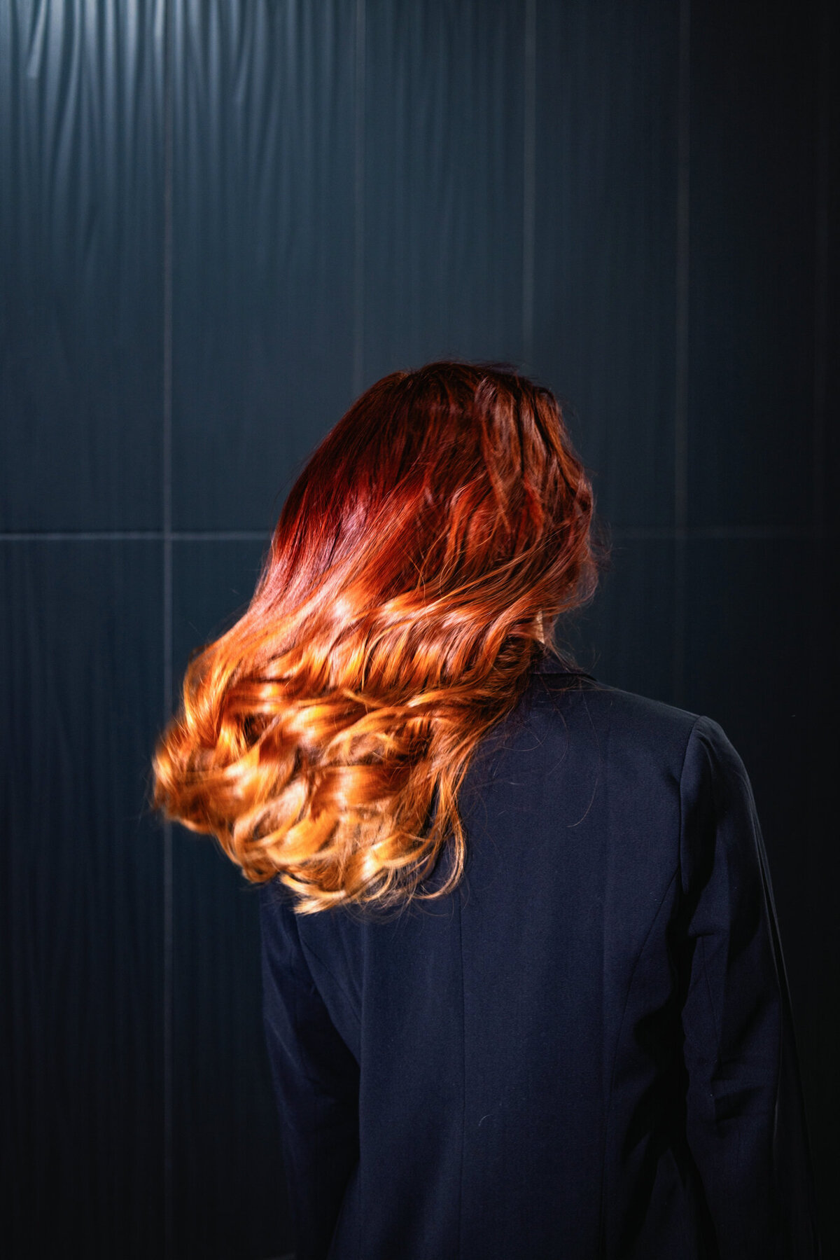 A stunning hair transformation with a deep red, ombré effect, styled to perfection. This image showcases the power of professional color services and expert styling techniques.