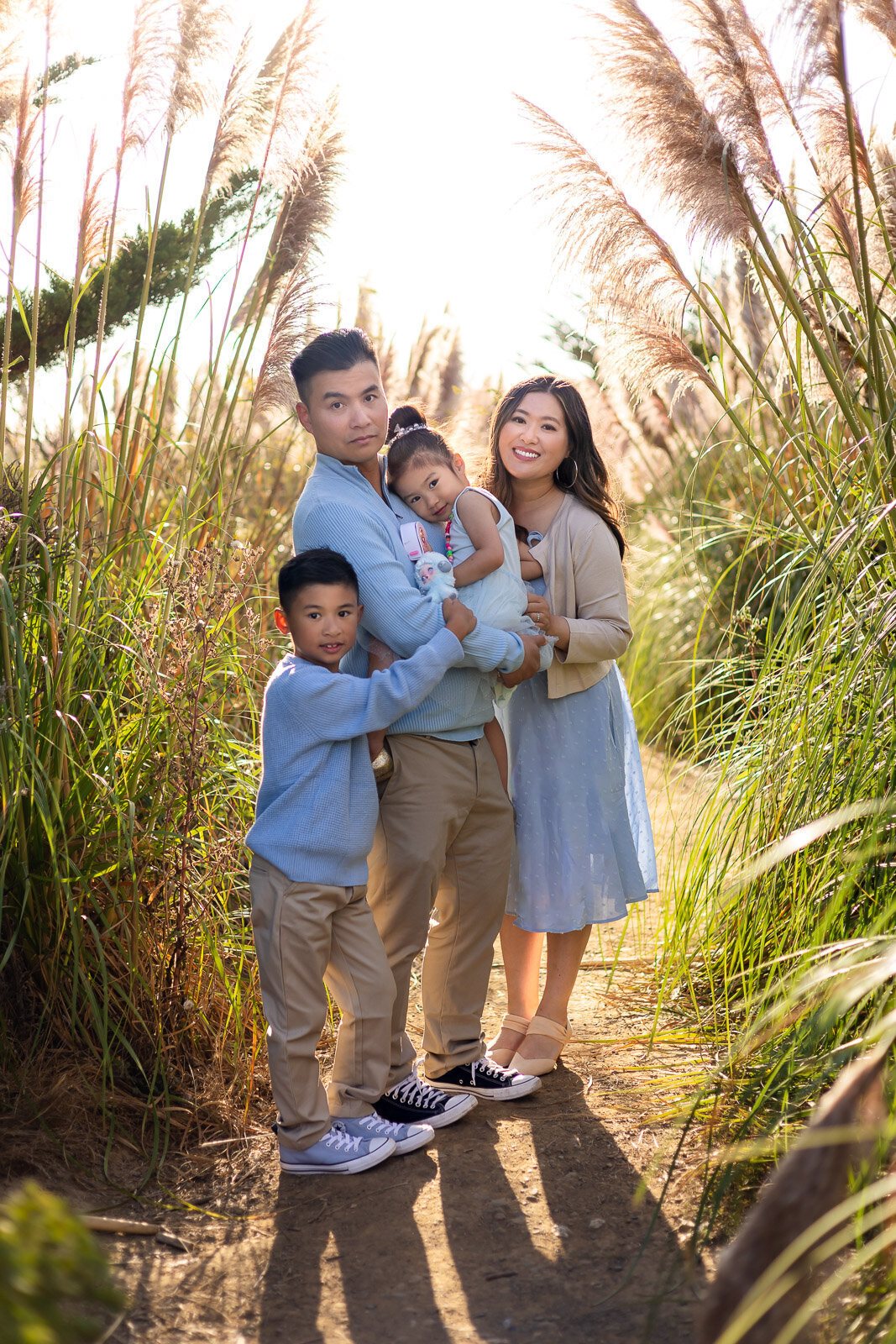 Family embracing on sunny trail with tall grass – Ellobelle Photography Bay Area Family Portfolio