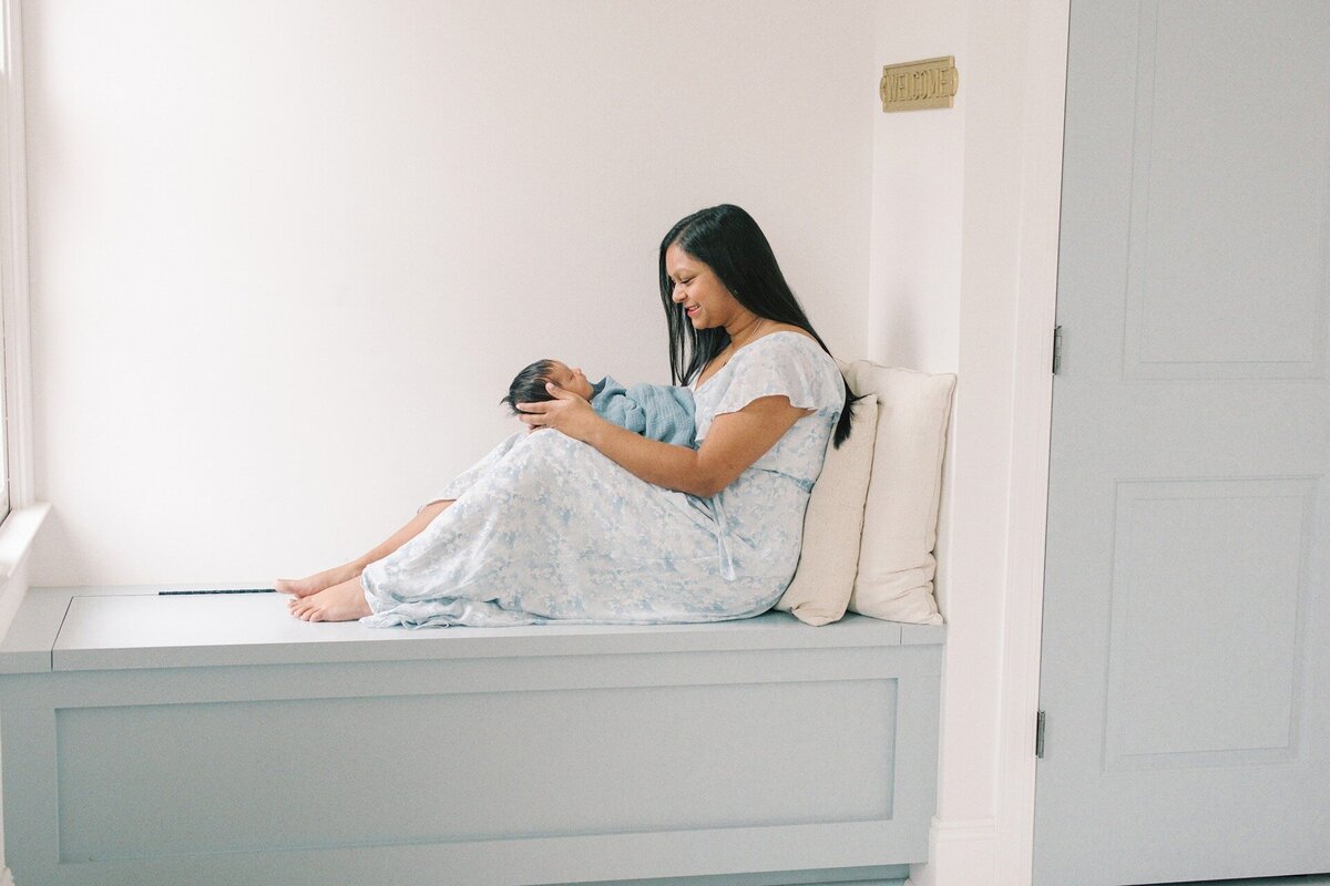 mom-sittingon-window-nook-holding-newborn