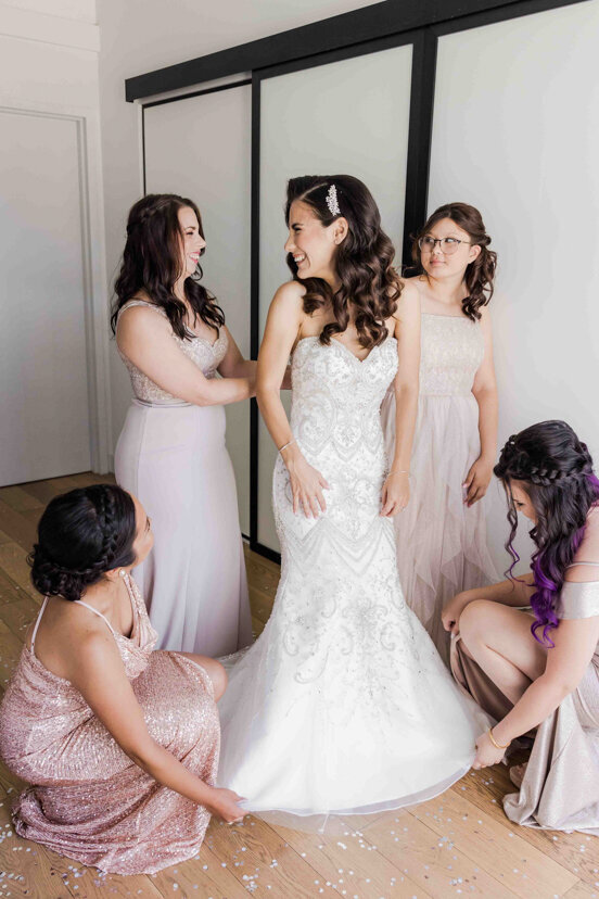 bridesmaids-helping-bride-dress