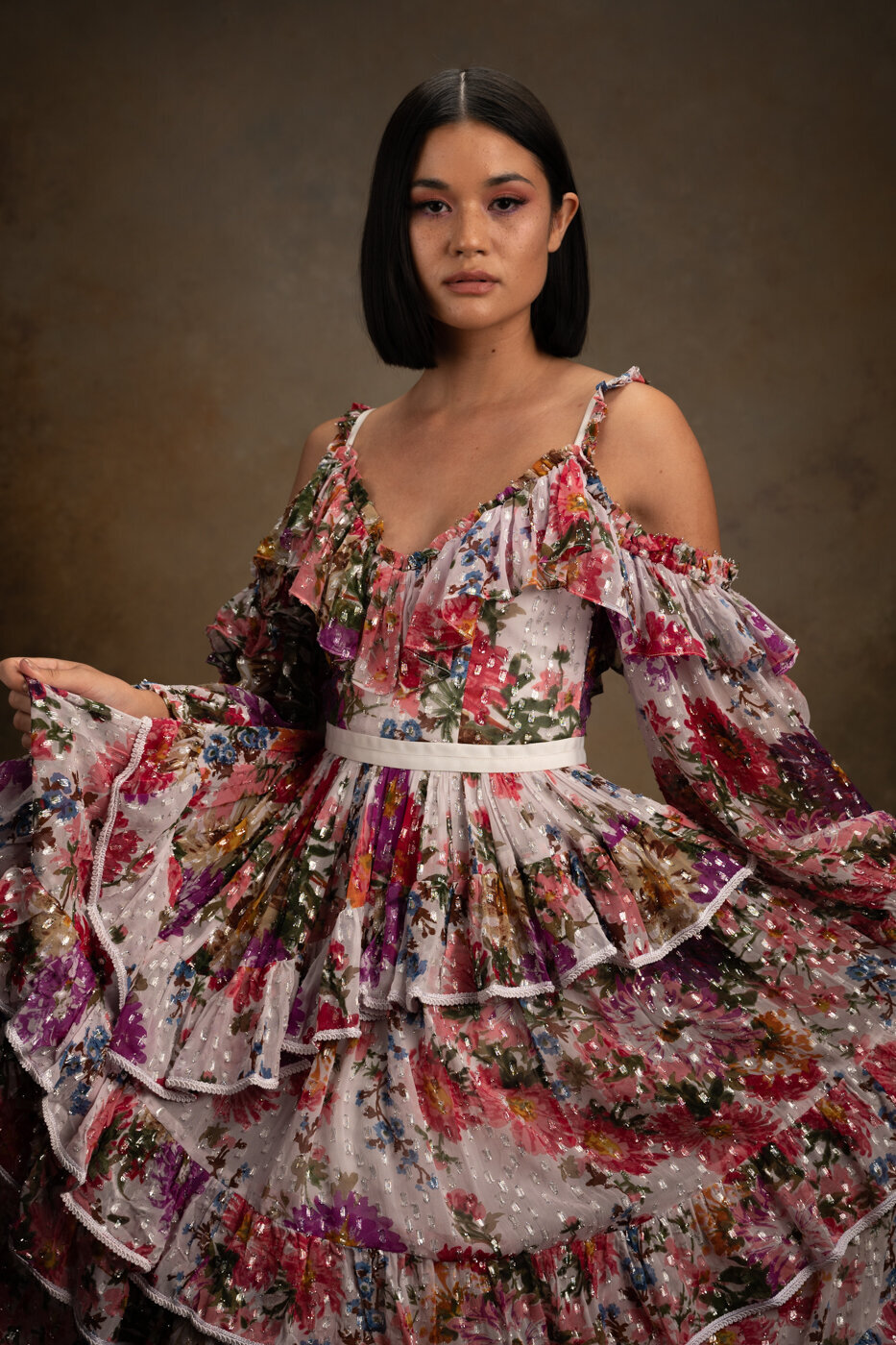 Woman looking with a strong and confidence attitude to the camera holding her dress with both arms
