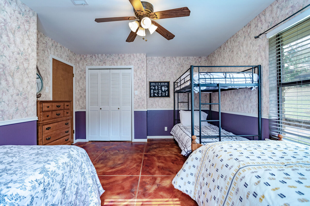 Bedroom with two beds and a set of bunk beds in this three-bedroom, two-bathroom ranch house for 7 with incredible hiking, wildlife and views.